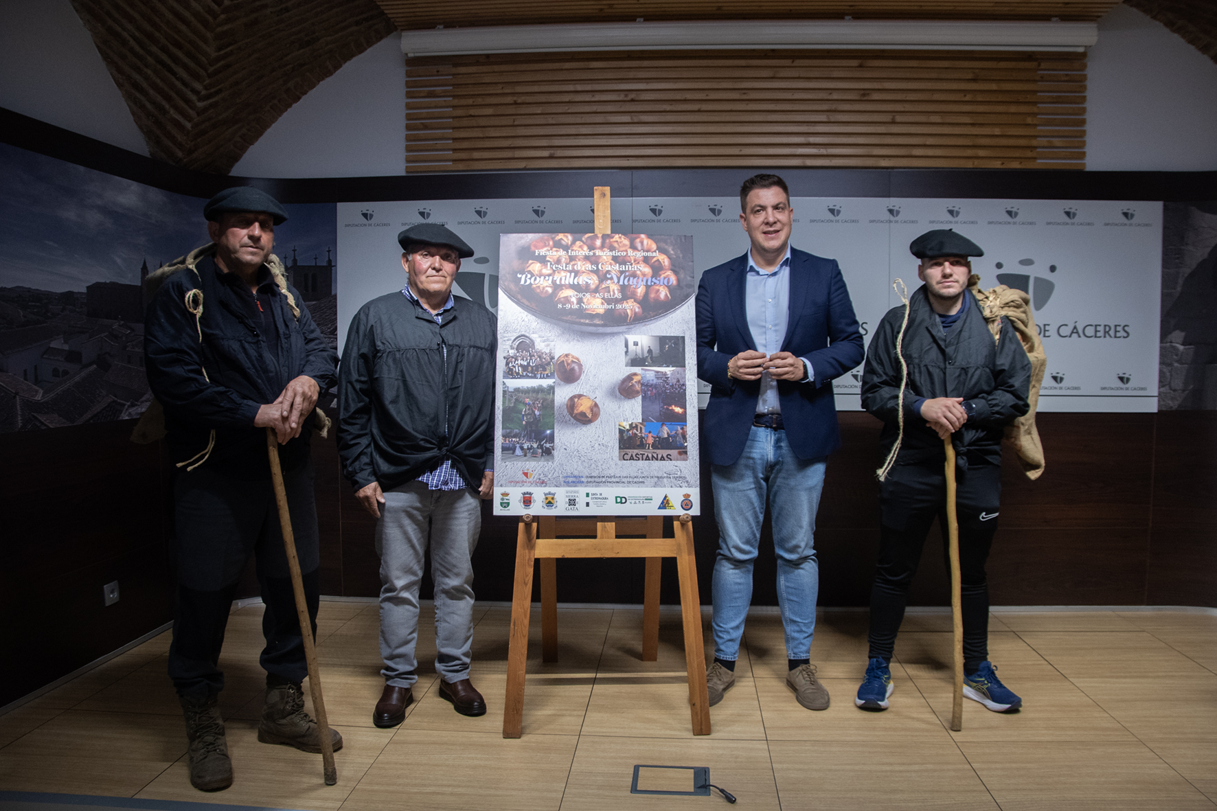 El diputado, el alcalde de Eljas y los otros organizadores posan junto al cartel y a la programación.